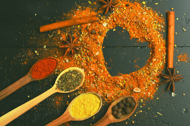 Set of spices on grey background. Wood spoons with paprika Set of spices on dark grey background. Wood spoons with paprika, turmeric, herbs and pepper by cinnamon and anise. Composition of condiment making heart shape. Cuisine and flavouring concept Cardamom stock pictures, royalty-free photos & images