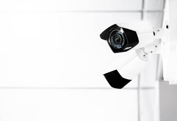 istock Modern public CCTV cameras on wall with blurred indoor background. Intelligent reccording cameras for monitoring all day and night. Concept of surveillance and monitoring with copy space. 1396868795