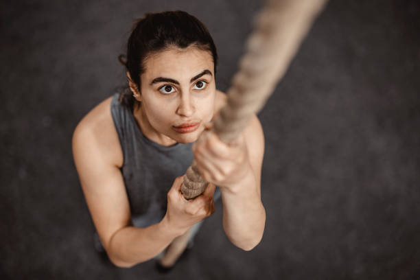 istock Female gym Athlete Climbing Rope 1396868835