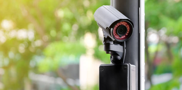 istock Modern public CCTV camera on a electric pole with blurred natural background. Intelligent reccording cameras for monitoring all day and night. Concept of surveillance and monitoring with copy space. 1396869428