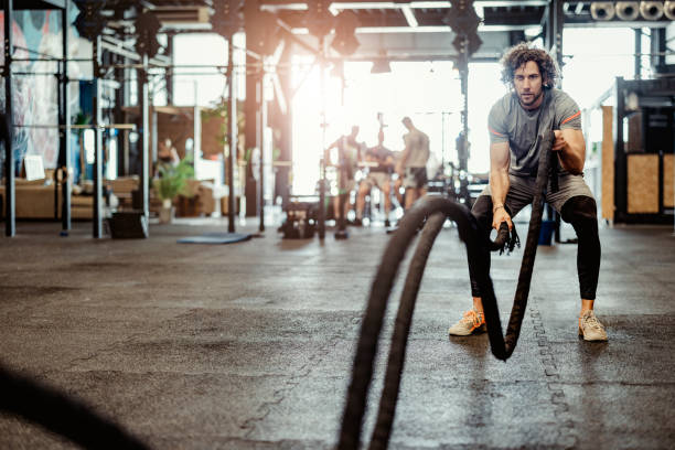 istock Man doing battle ropes exercise at the gym gym 1396869442