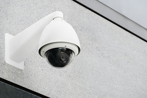 Modern public CCTV cameras on white wall. Intelligent reccording cameras for monitoring all day and night. Concept of surveillance and monitoring with copy space and clipping path.