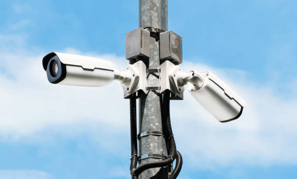 istock Modern public 360 degree CCTV cameras with bright sky background. Intelligent reccording cameras for monitoring all day and night. Concept of surveillance and monitoring with copy space. 1396869537