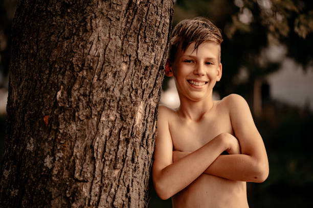istock A boy poses near a tree in a summer park. 1396869553