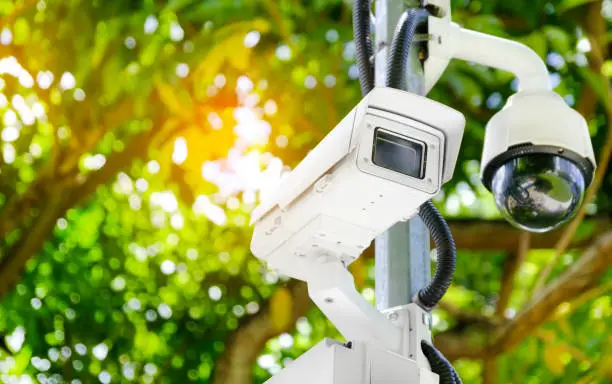 Photo of Modern public CCTV camera on a electric pole with blurred natural background. Intelligent reccording cameras for monitoring all day and night. Concept of surveillance and monitoring with copy space.