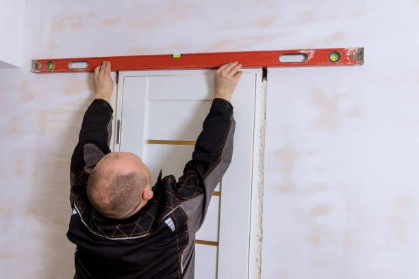 istock Carpenter at checks level correctness installation door 1396869630