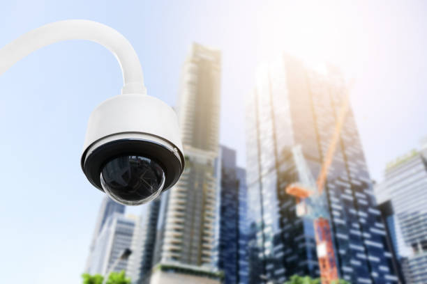 istock Modern public CCTV camera on electric pole with blur building background. Recording cameras for monitoring all day and night. Concept of surveillance and monitoring with copy space. 1396870927