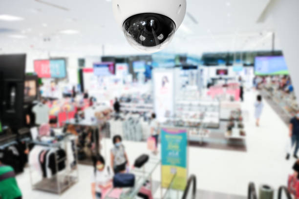 istock Modern public CCTV camera with blur interior shopping mall background. Recording cameras for monitoring all day and night. Concept of surveillance and monitoring with copy space. 1396870935