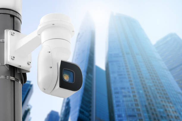 istock Modern public CCTV camera on wall with blur building background. Recording cameras for monitoring all day and night. Concept of surveillance and monitoring with copy space. 1396870939