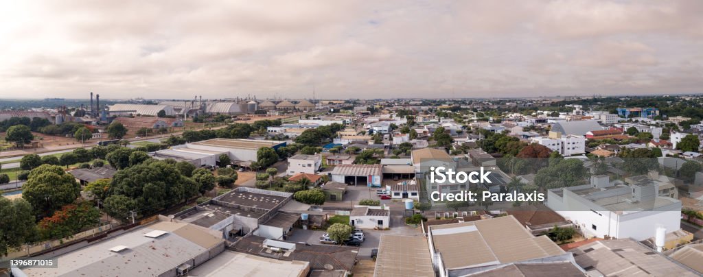 Drone aerial view of Sorriso city skyline, buildings, houses and BR 163 road on cloudy summer day, Amazon, Mato Grosso, Brazil. Concept of cityscape, landmark, architecture, logistics, transport. Aerial View Stock Photo
