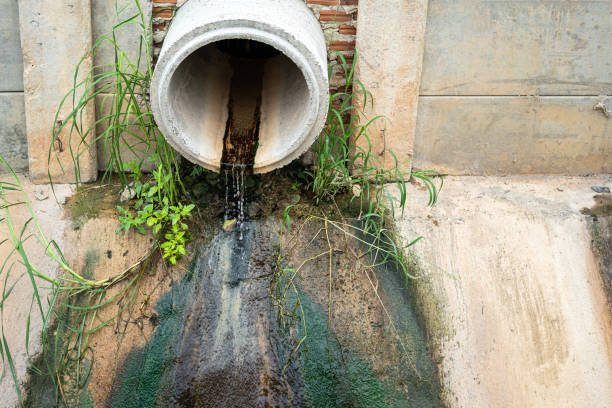 istock Industrial sewage water draining out from cement tube. 1396871083
