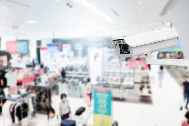 istock Modern public CCTV camera with blur interior shopping mall background. Recording cameras for monitoring all day and night. Concept of surveillance and monitoring with copy space. 1396871098