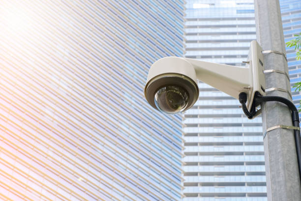 istock Modern public CCTV camera on electric pole with blur building background. Recording cameras for monitoring all day and night. Concept of surveillance and monitoring with copy space. 1396873234