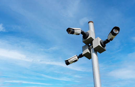 Modern public CCTV camera with clear sky background. Recording cameras for monitoring all day and night. Concept of surveillance and monitoring with copy space.