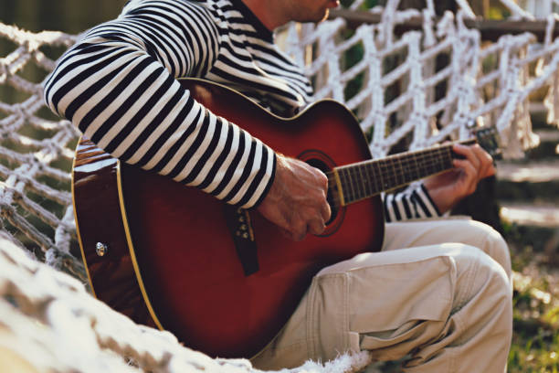 facet chłodzący się na hamaku z gitarą - fingerstyle zdjęcia i obrazy z banku zdjęć