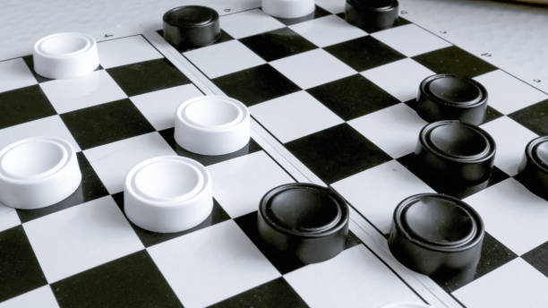istock checkers game, hobby. Close-up of a hand moving checkers, fast shooting effect 1396874612