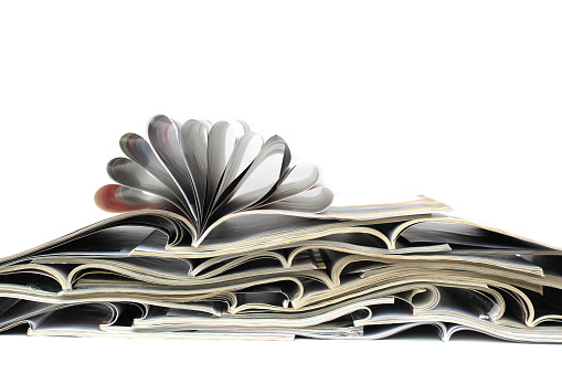 A pile of magazines lies in a pile.
