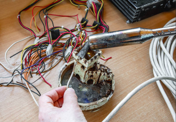 istock The technician covers the copper wire with tin using an electric soldering iron 1396875324