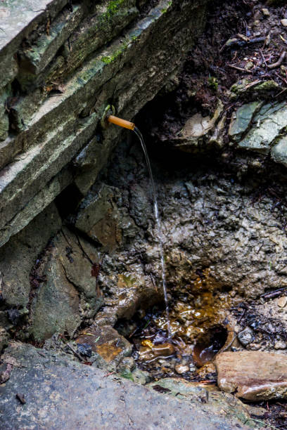 istock clear minerail water flows from the pipe into the Carpathian forest 1396876311