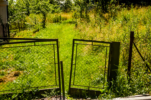 an old rusty gate and fence of abandoned rural yard