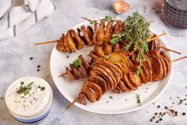 patate tornado croccanti. patatine fritte su spiedini, arrostite con timo e spezie. - roasted potatoes prepared potato herb food foto e immagini stock