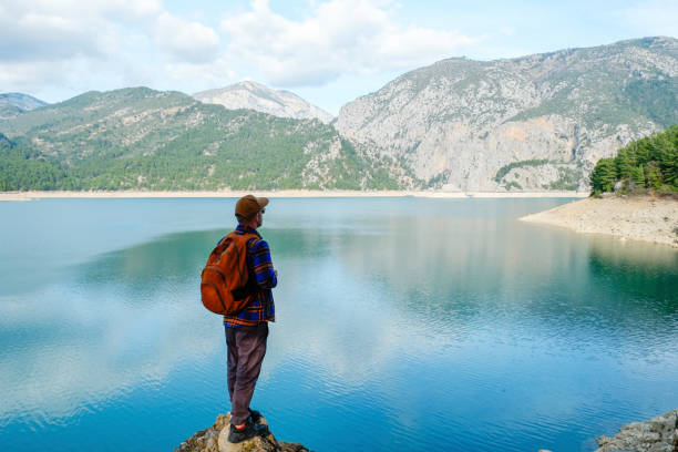 istock Traveler with bright orange backpack at beautiful destination. 1396877643
