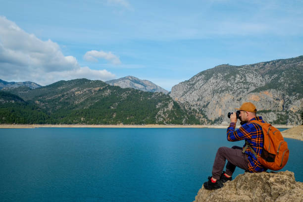 istock Traveler with bright orange backpack at beautiful destination. 1396877911