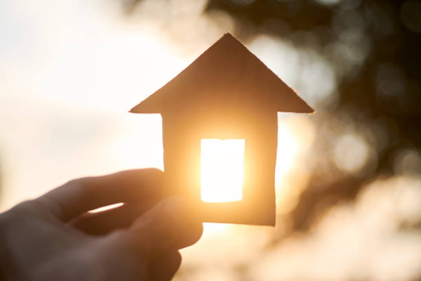 istock Construction concept with renewable resources, cardboard house with sunlight in the back. 1396878633