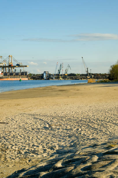 промышленная зона на побережье. большие краны на заднем плане. порт - barge beach large blue стоковые фото и изображения