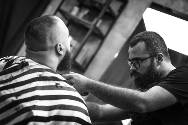 istock Hipster barber working in a retro vintage barber shop 1396884144