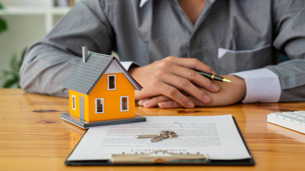 empresários segurando canetas, assinando títulos de casa com seguro, preocupação com serviços imobiliários e a ideia de corretores de imóveis oferecendo interesse em parcelas aos seus clientes. - real food fotos - fotografias e filmes do acervo