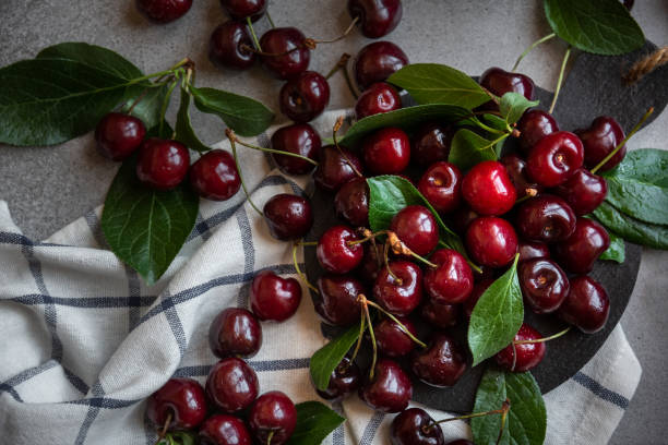 istock Fresh ripe dark cherry fruit with green leaves 1396885477