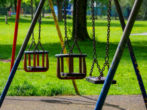 детские качели в общественном парке солнечный летний день - swing playground empty abandoned стоковые фото и изображения