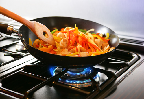 Wok cooking Stirfry vegetables and chicken on Gas flame.