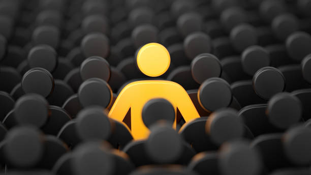 Yellow human shape among dark ones. Standing out of crowd concept stock photo