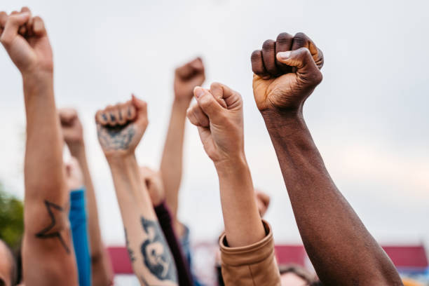 Protestors Raising Fists Close-up of protestors raising hands above their heads. labor union stock pictures, royalty-free photos & images