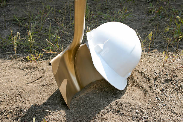 Groundbreaking Tools A hard hat and golden shovel await  their use in a groundbreaking ceremony. ceremony photos stock pictures, royalty-free photos & images