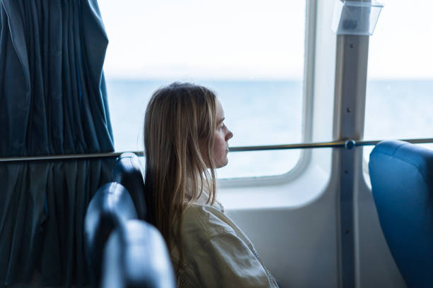 Young woman relaxes on train seat, on holiday stock photo
