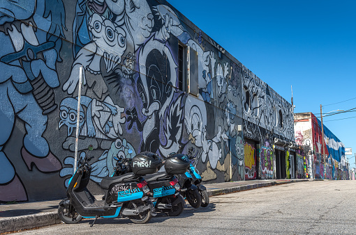 Miami, Florida - May 12, 2022: Rental service, through smartphone applications, of small motorcycles in the artistic neighborhood of Wynwood, Miami.