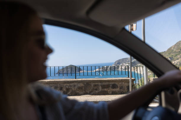 une jeune femme conduit le long de la route côtière - italy two lane highway driving people traveling photos et images de collection