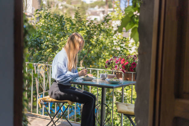 istock Young woman enjoys a healthy breakfast outside 1396895599