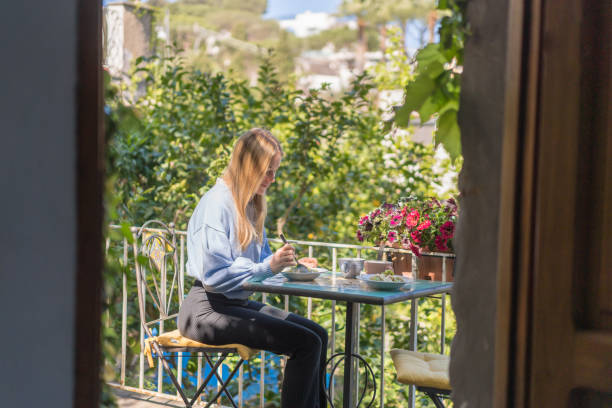istock Young woman enjoys a healthy breakfast outside 1396895603