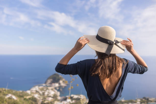 istock Young woman relaxes at coastal viewpoint 1396896245