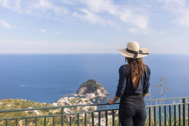 istock Young woman relaxes at coastal viewpoint 1396896295