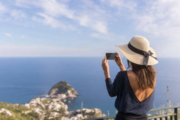 istock Young woman relaxes at coastal viewpoint 1396896410