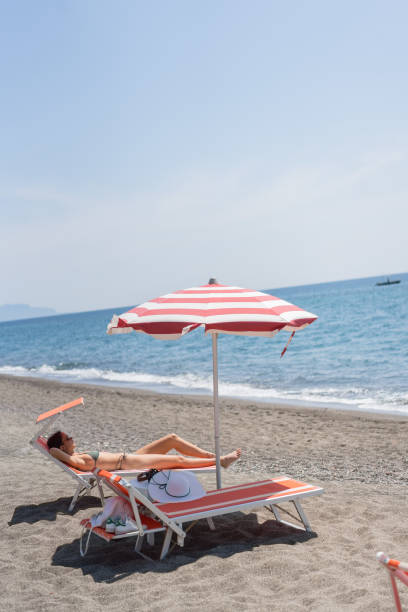 istock Young woman sun tans on sandy beach 1396896714