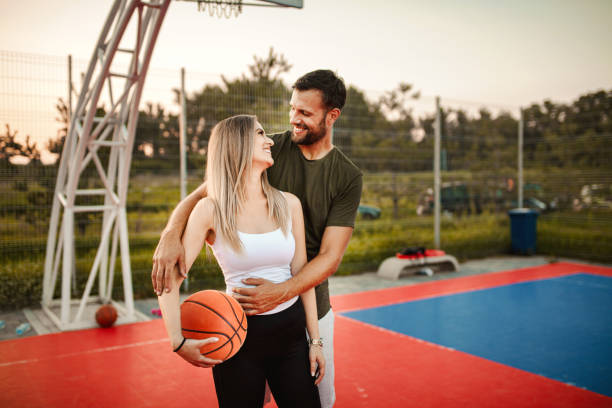 istock Young happy couple having fun while playing basketball 1396896861