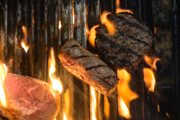 istock Preparing Meat and Burger on a barbeque grid fire with smoke and flames directly above 1396900215
