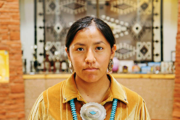A portrait of a Native American Navajo woman standing.