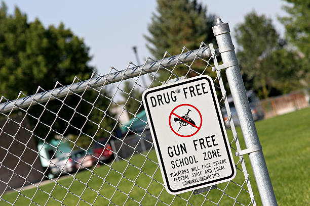 drug and gun free school zone drug and gun free school zone sign at a school yard. sign of the times. school alarm stock pictures, royalty-free photos & images